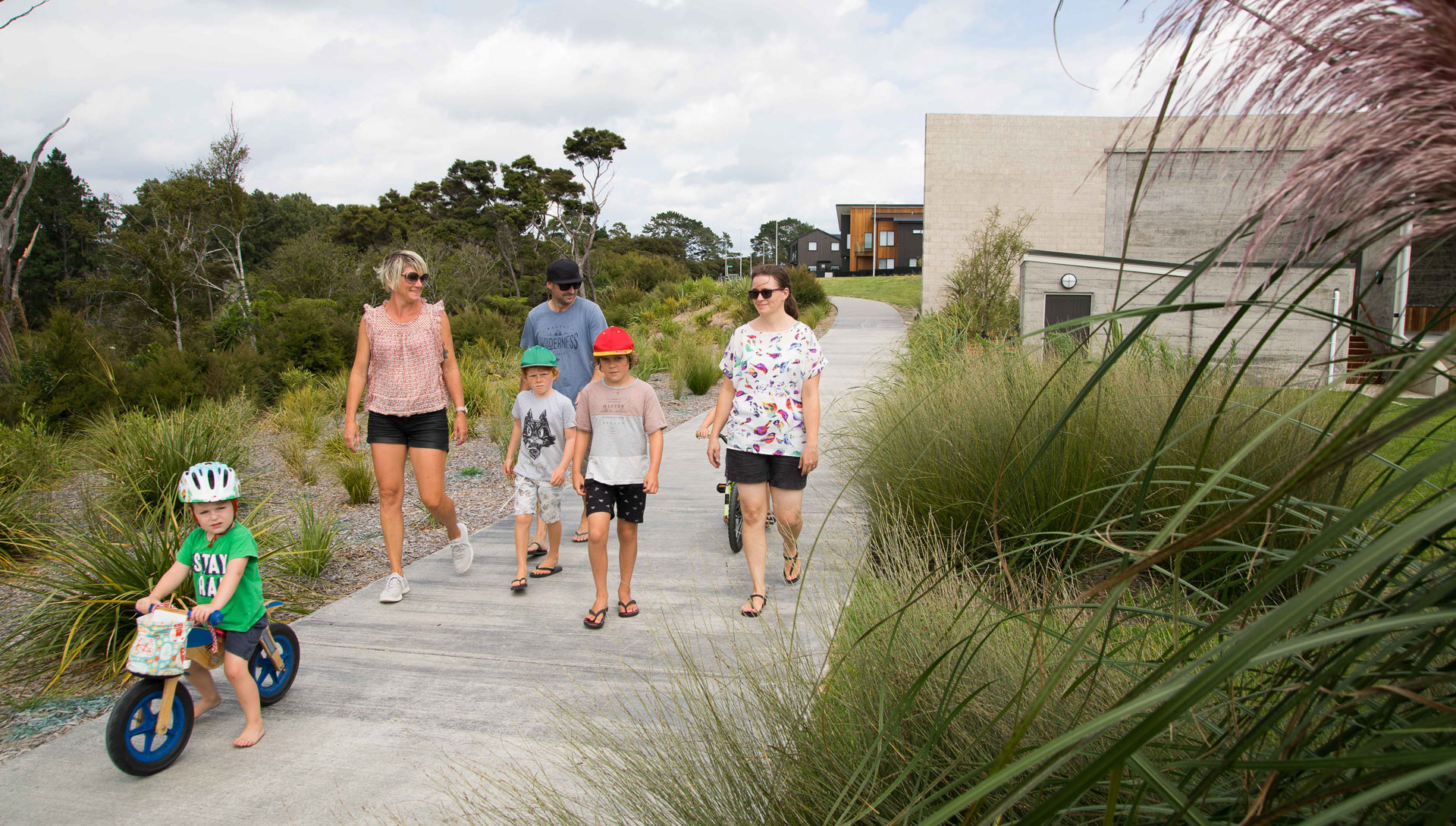 Families walking and biking the Hobsonville Point coastal boardwalk
